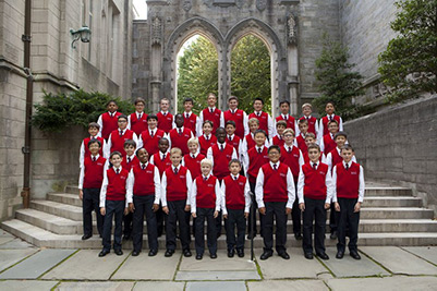 The American Boychoir standing on steps in front of a gothic archway.